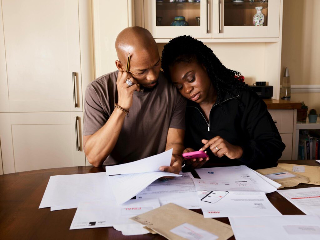 Managing the cost of living in Denmark: A couple sitting by a table calculating expenses