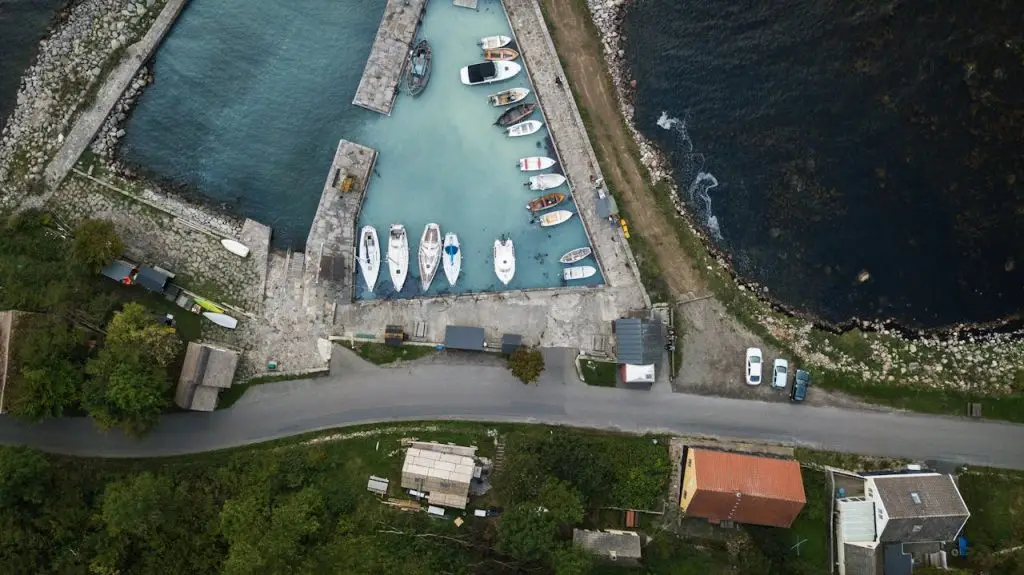 An aerial view of a scenic coastal harbor with boats and lush greenery, highlighting what is Denmark famous for, including its maritime heritage and natural beauty.