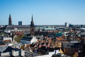 A scenic cityscape of Copenhagen, featuring historic spires and colorful rooftops, prompting the question: where is Copenhagen located?